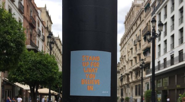 Stand up for what you believe in sticker on a lamp poll
